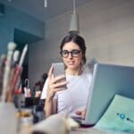 woman-in-white-t-shirt-holding-smartphone-in-front-of-laptop-914931 (1)